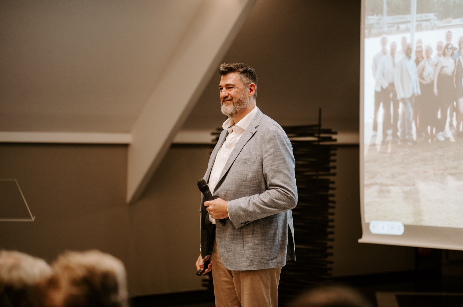 Tony Wood standing beside a projected slide during a talk.