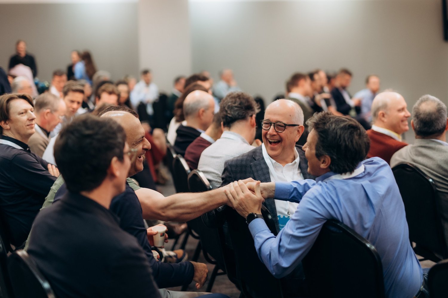 People smiling and greeting one another at a CEO CF gathering.