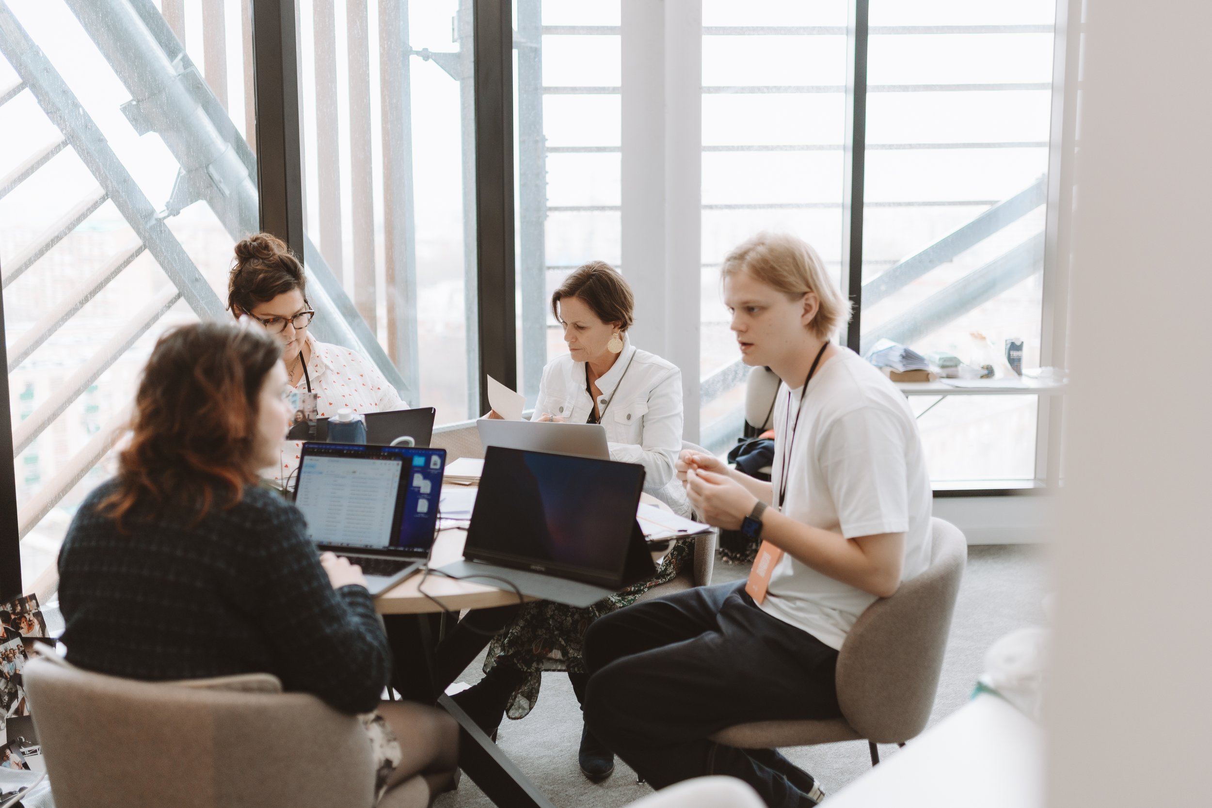 People working together around a table with laptops and papers, in a photograph from CEO CF